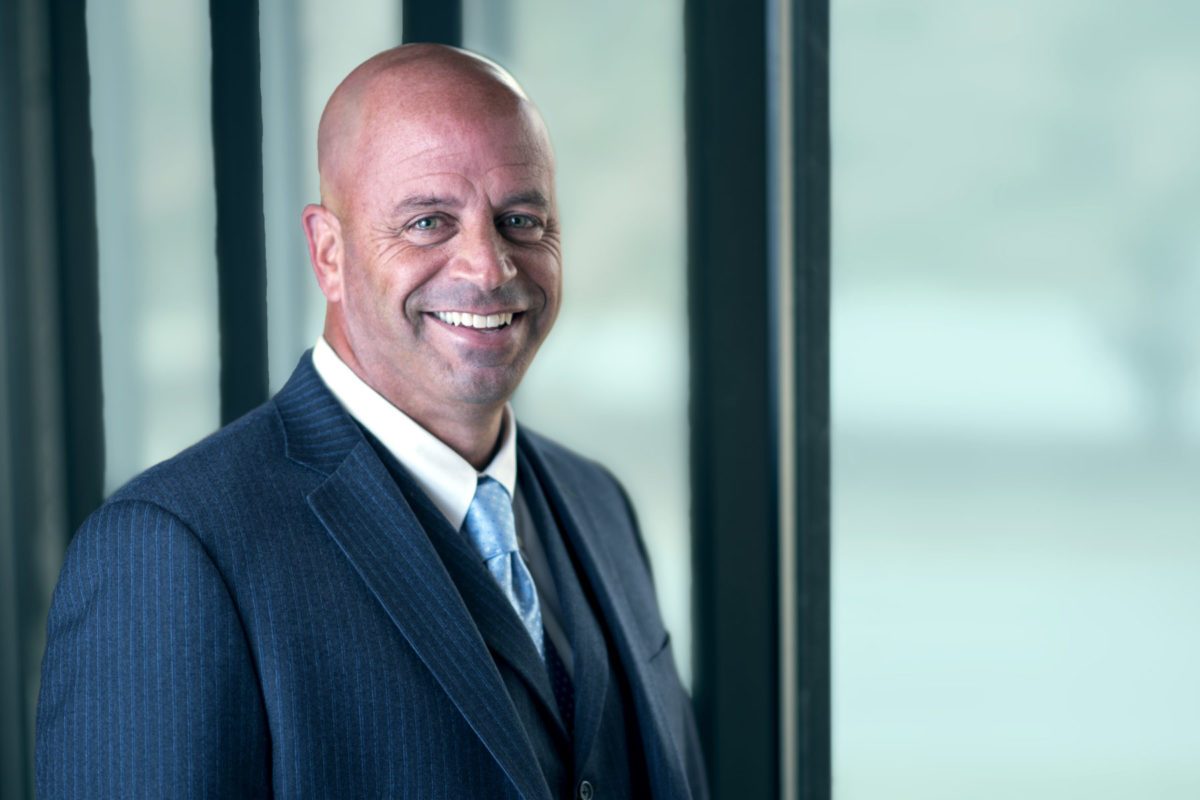 Professional head shot image of businessman in front of window